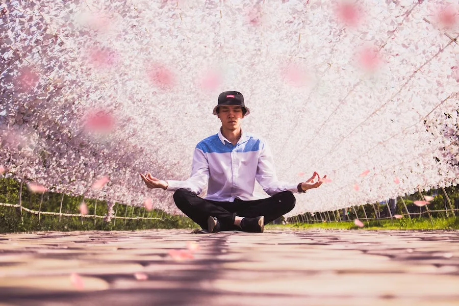 man sitting in yoga pose meditating with finger mudras