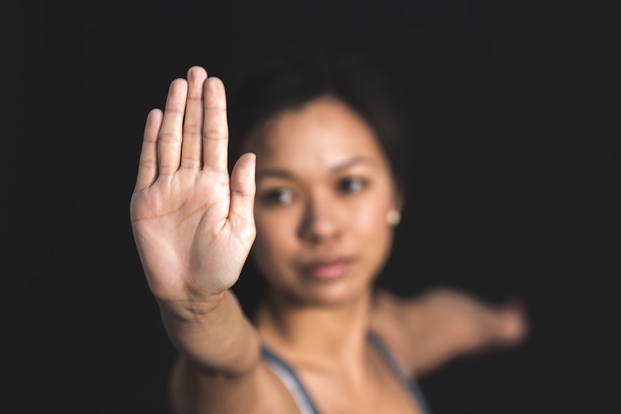 woman holding hand up pushing away during yoga