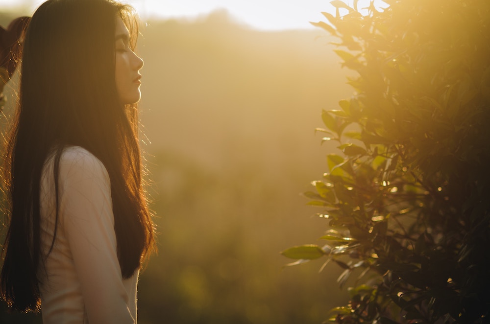 asian woman basking in the sun rays