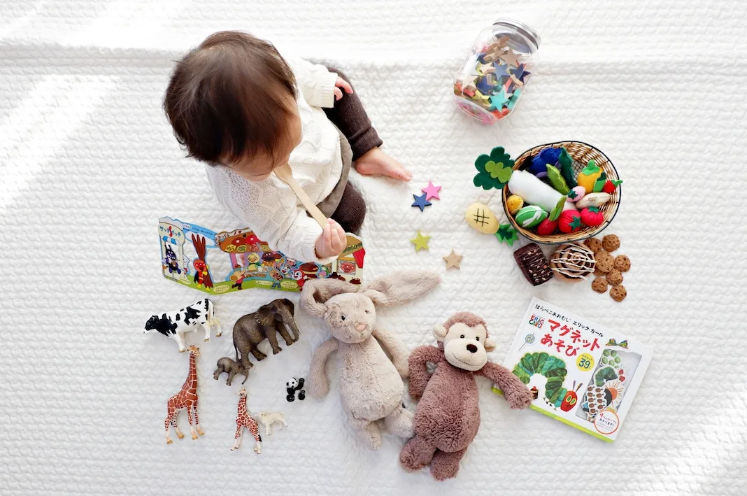 baby playing with toys on bed