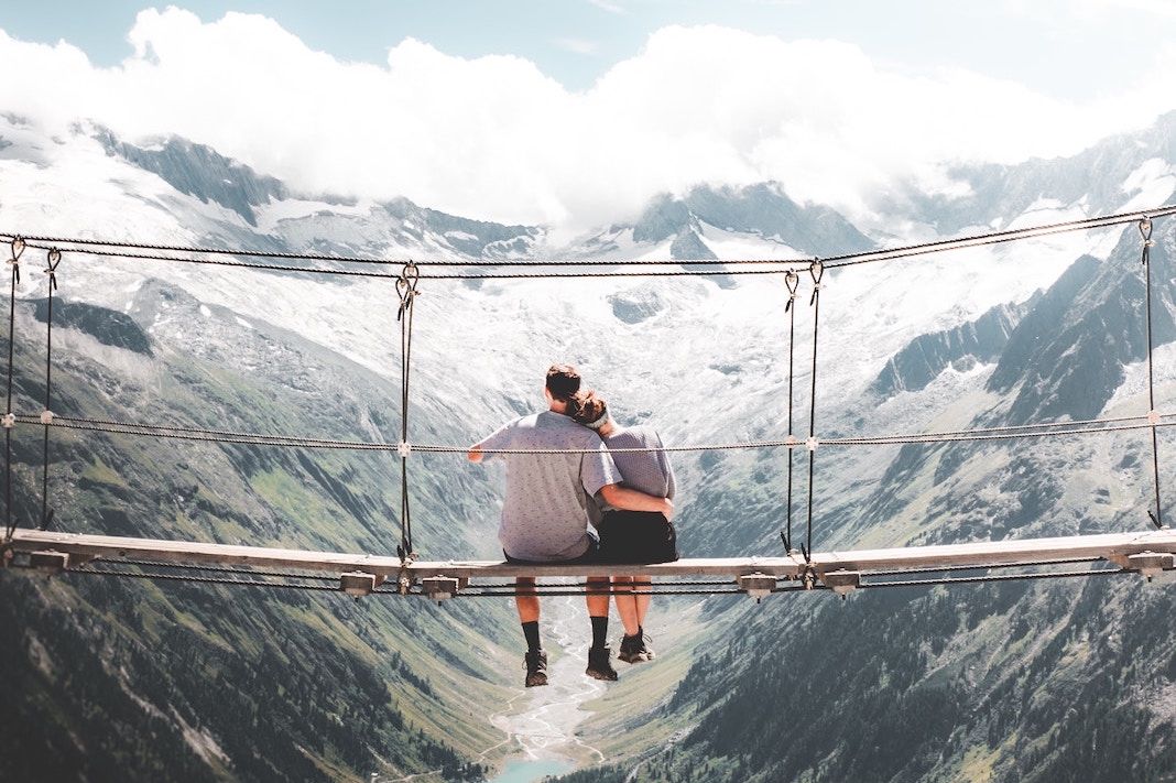 man and woman embracing on bridge