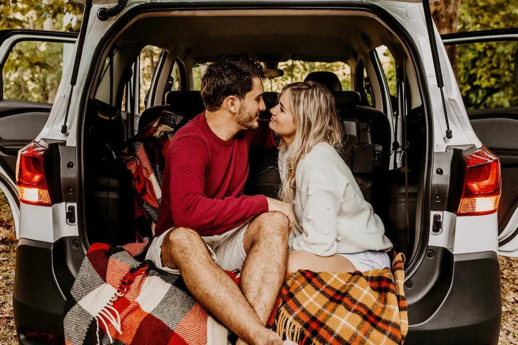 loving couple in back of car with blankets
