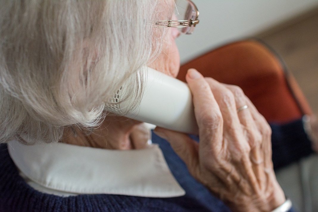 elderly woman talking on the phone with family