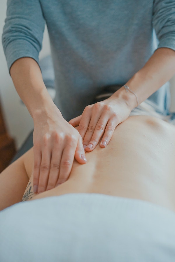 chiropractor massage back of woman