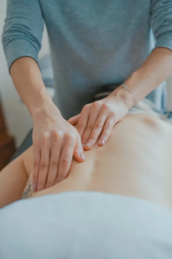 chiropractor massage back of woman