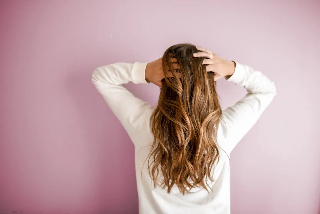 woman scratching her scalp and hair from behind