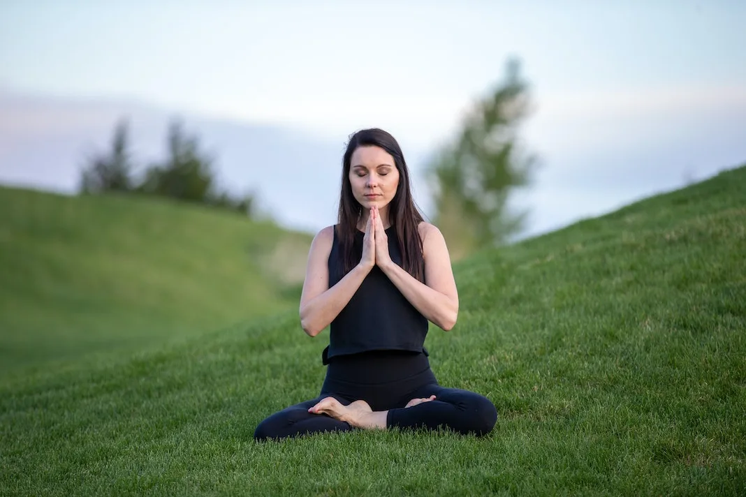 woman meditating on the hill