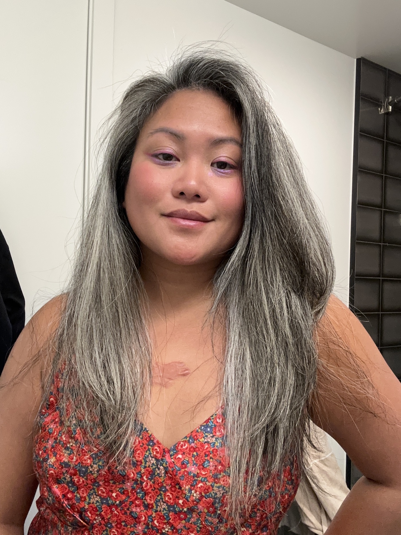 Asian woman with gray hair using DigitalAire hair dryer by Conair